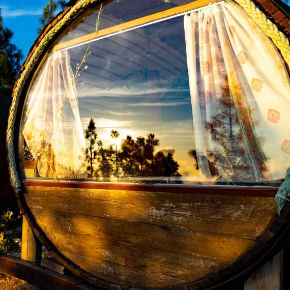 A romantic barrel-shaped house with a terrace and a view of the forest and the ocean.